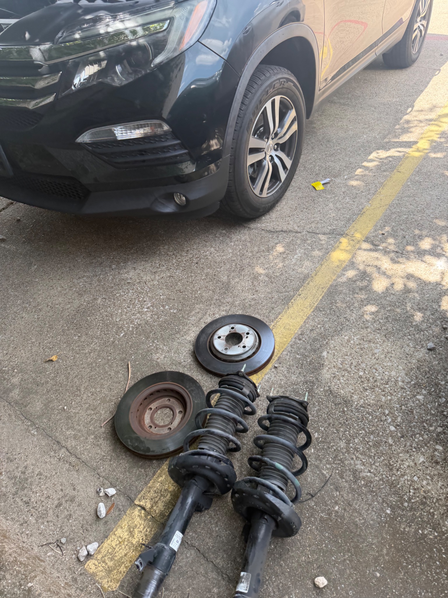 Brake and suspension components removed during a mobile repair